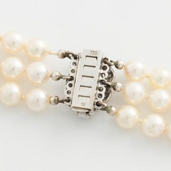 Necklace, three-stranded with cultured pearls, clasp in white gold with sapphires and small diamonds.