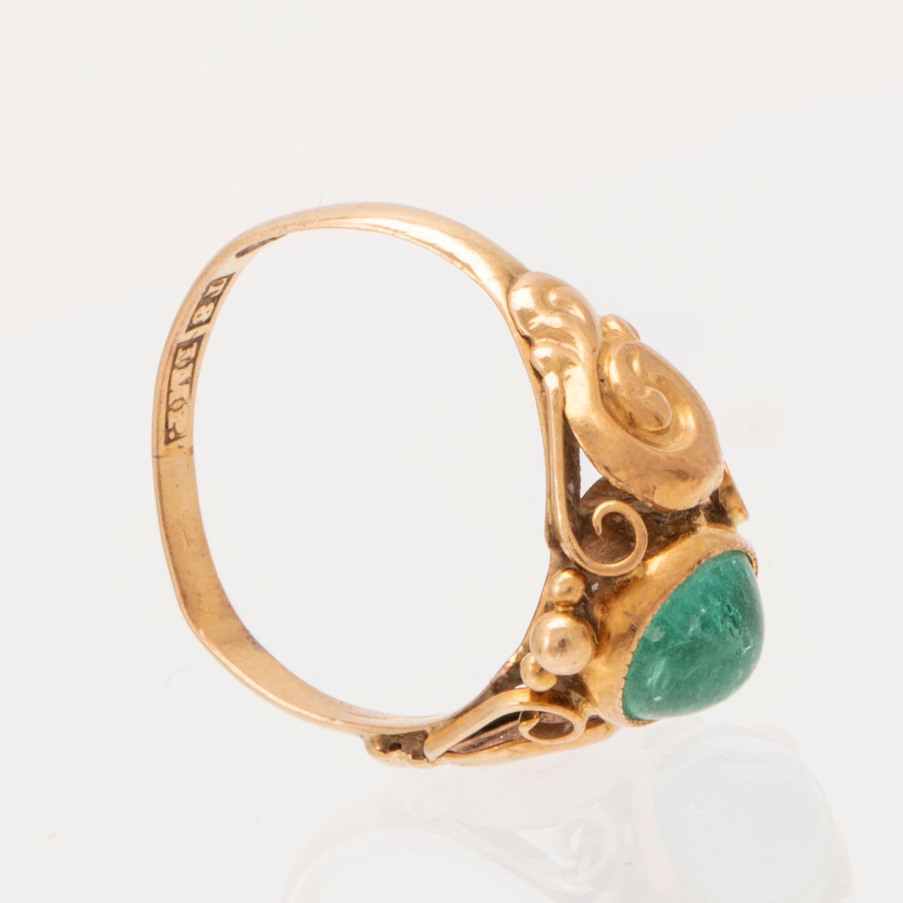An 18K gold ring set with a cabochon cut emerald by Harbeck Wilhelm Stockholm 1945.