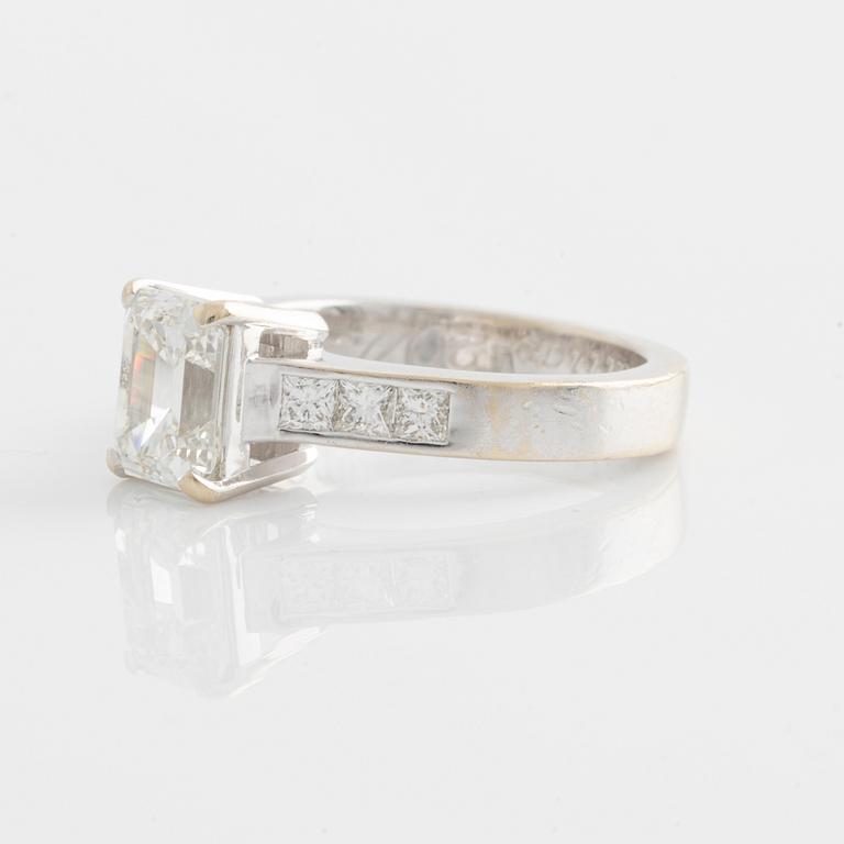 An 18K white gold ring set with an emerald-cut diamond.
