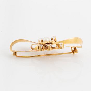 An 18K gold brooch set with a cultured pearl and white stones.