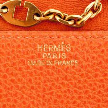 HERMÈS, a orange leather key holder.