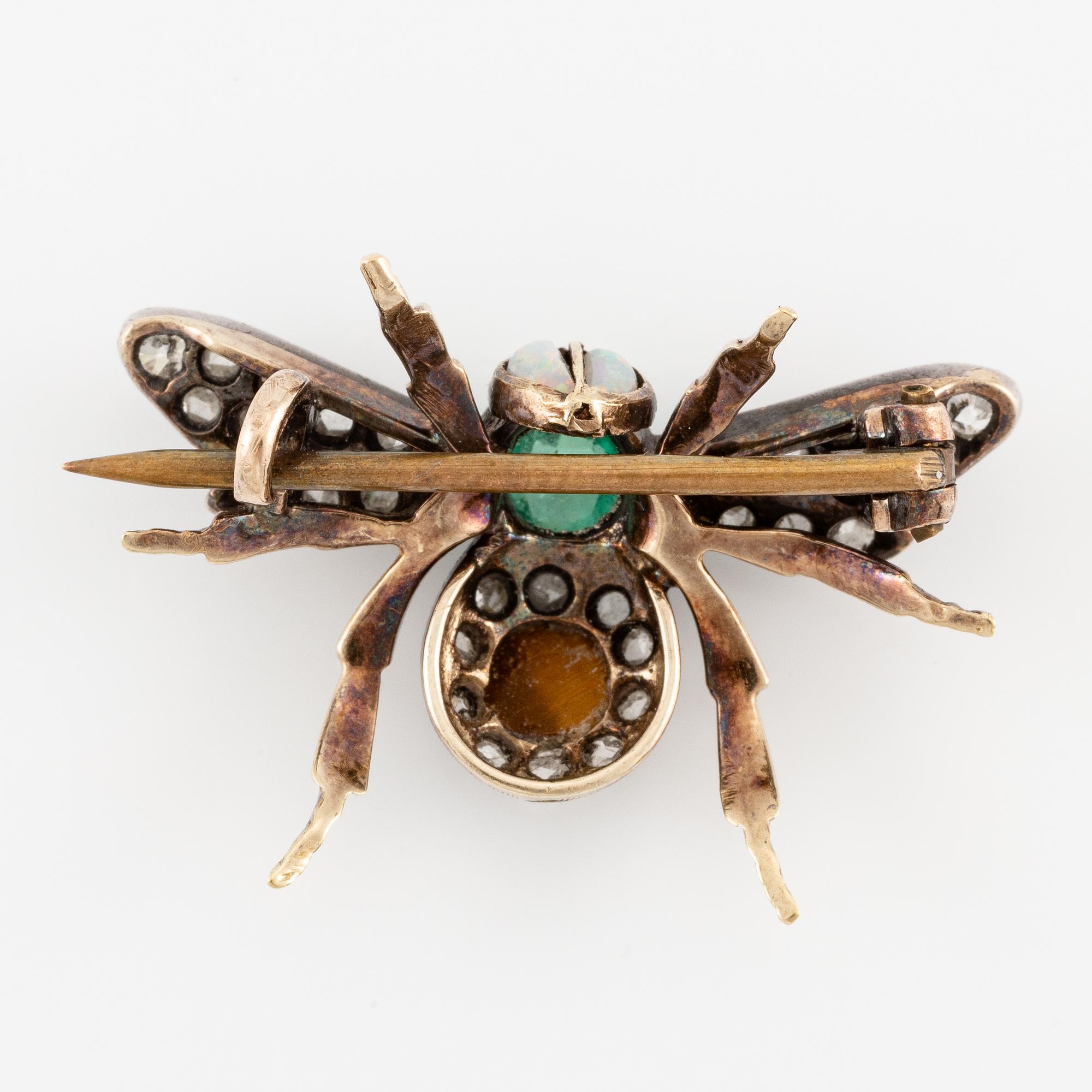 A brooch in silver and 14K gold with coloured gemstones and rose-cut diamonds.