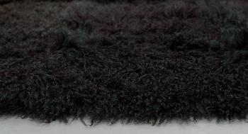 A carpet, sheepskins, black dark brown green melange, ca 547 x 492-498 cm.