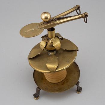 A brass candleholder with wax candle. 19th century.