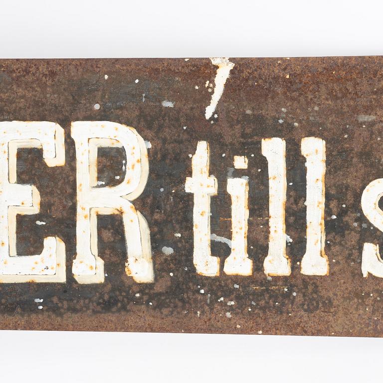 Skylt, järn, 1900-talets första hälft.