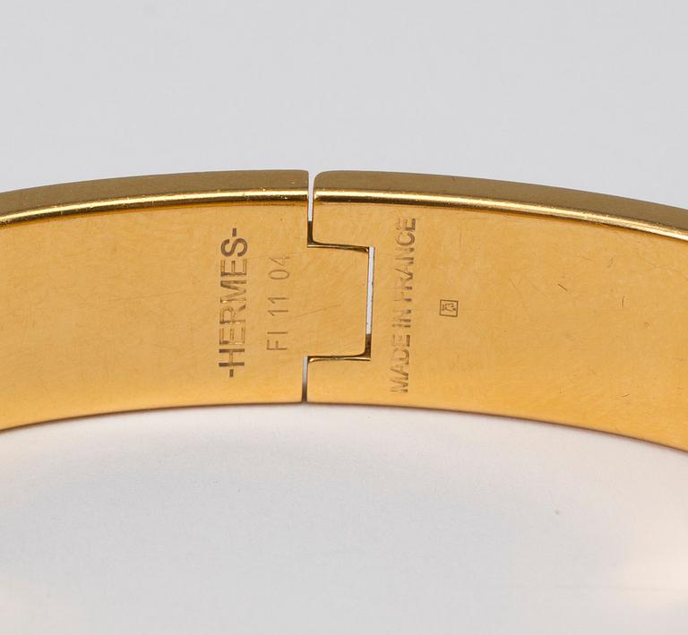 Black enamel and golden bracelet "Clic H" by Hermès.