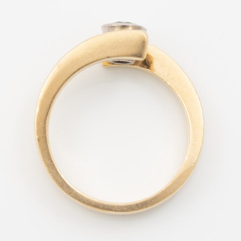 18K gold ring with a round brilliant-cut diamond.