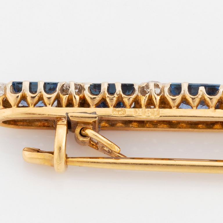 An 18K gold brooch set with step-cut sapphires and old-cut diamonds.