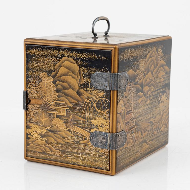 A Japanese lacquer cabinet with tree drawers behind the door, early 20th Century.