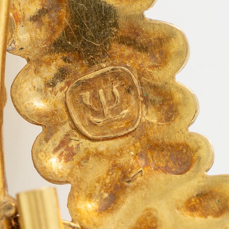 Brooch, 18K gold with cabochon-cut ruby, decoration of leaves.