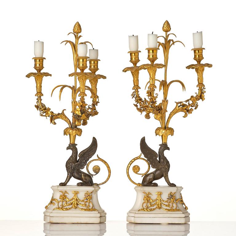A pair of three-light Louis XVI patinated and ormolu candelabra in the manner of François Rémond, late 18th century.