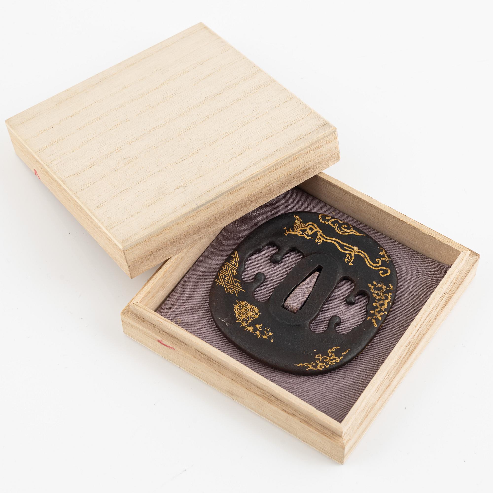 An iron part gilt Japanese tsuba, Edo (1603-1868). In a kiri box.