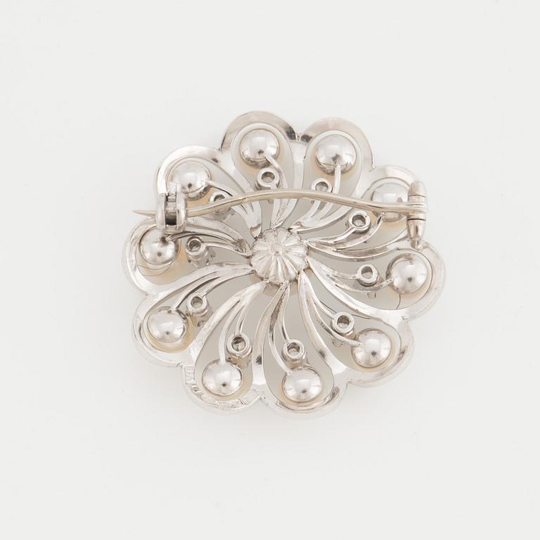 A brooch set with cultured pearls and round, brilliant-cut diamonds.