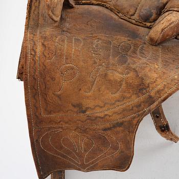 A leather saddle of Caucasian type, dated 1821.