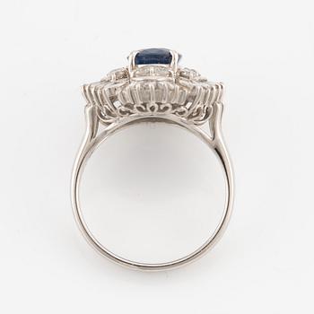 Ring in platinum set with a faceted sapphire and round brilliant- and baguette-cut diamonds.