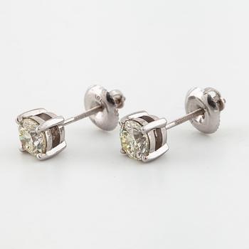 A pair of brilliant cut diamond earrings.