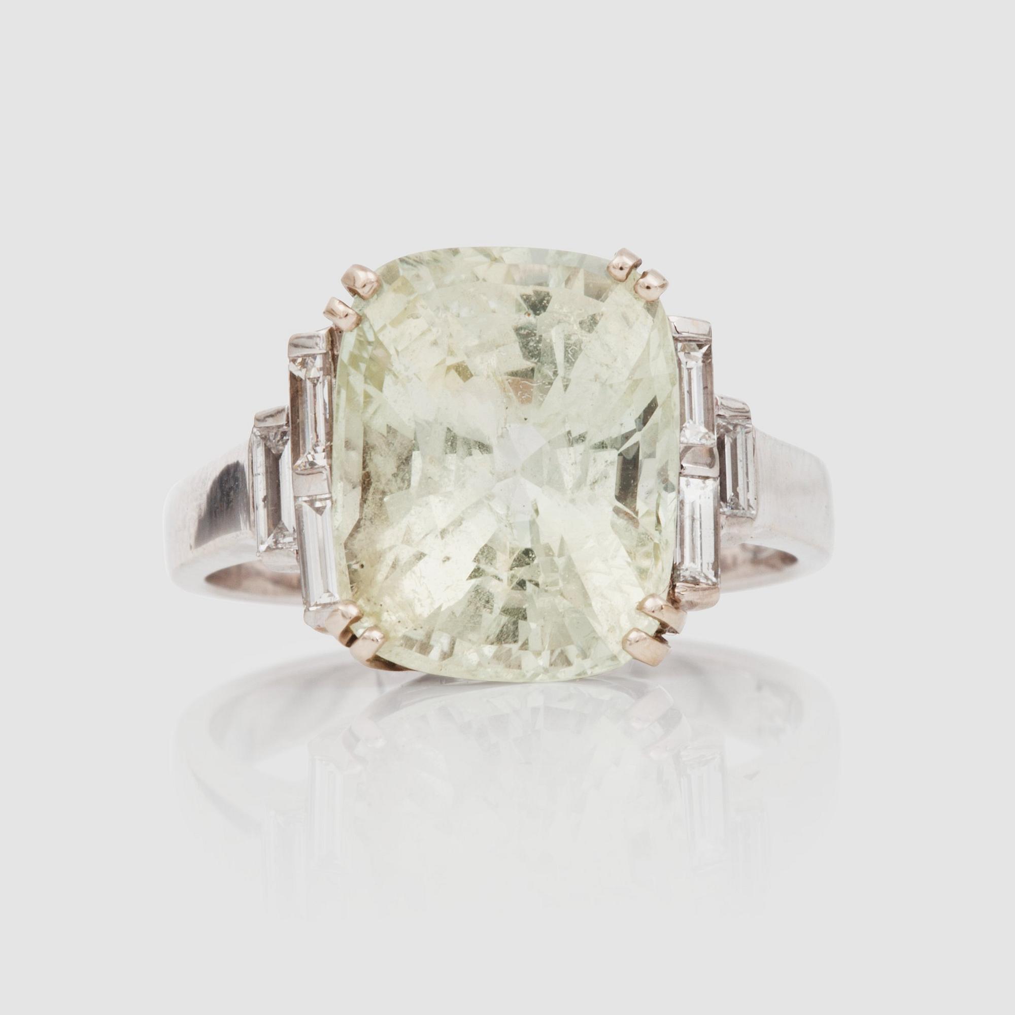 RING med naturlig gröngul safir, 7.85 ct enligt GRS cert, samt baguetteslipade diamanter totalt cirka 0.30 ct.