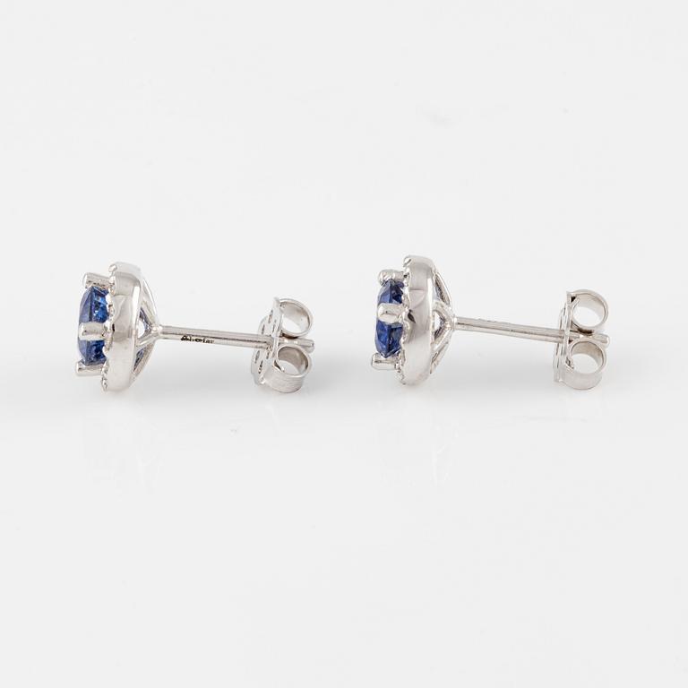 A pair of 18K gold earrings with faceted sapphires and round brilliant-cut diamonds.