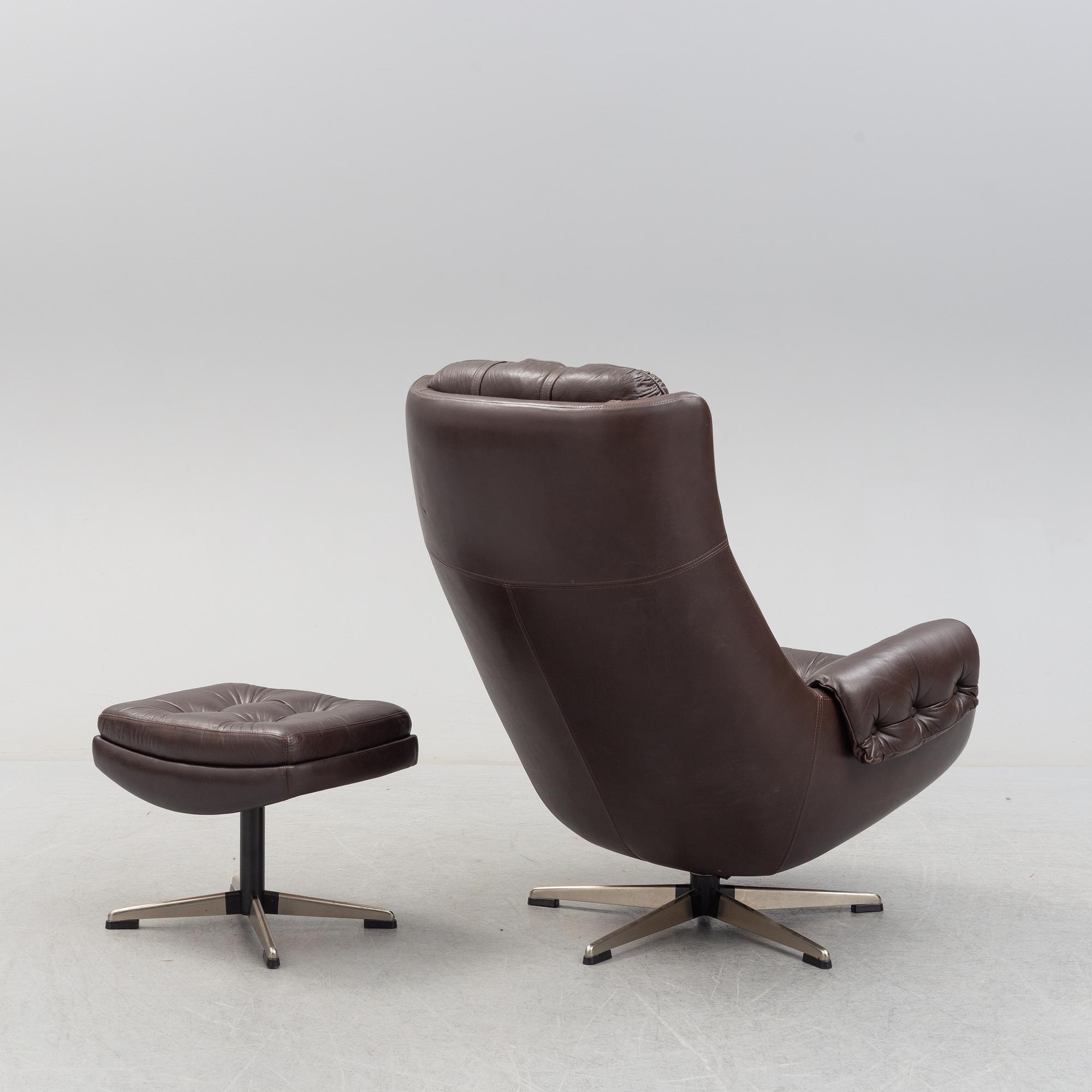 A leather upholstered easy chair with foot stool, 1960's/70's.