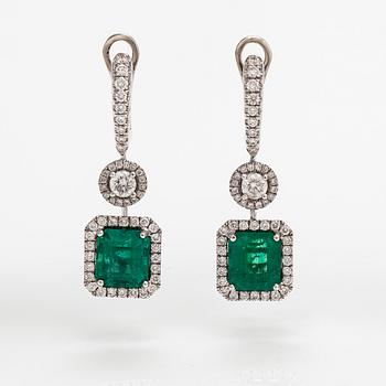A pair of 18K white gold earrings with diamonds ca. 1.05 ct in total and emeralds ca. 4.20 ct in total. With certificate.