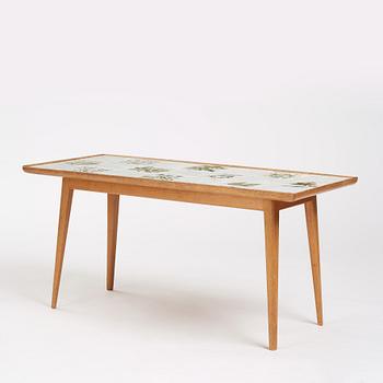 a Swedish Modern coffee table, decorated with Jobs' ceramic tiles, signed and dated 1941.