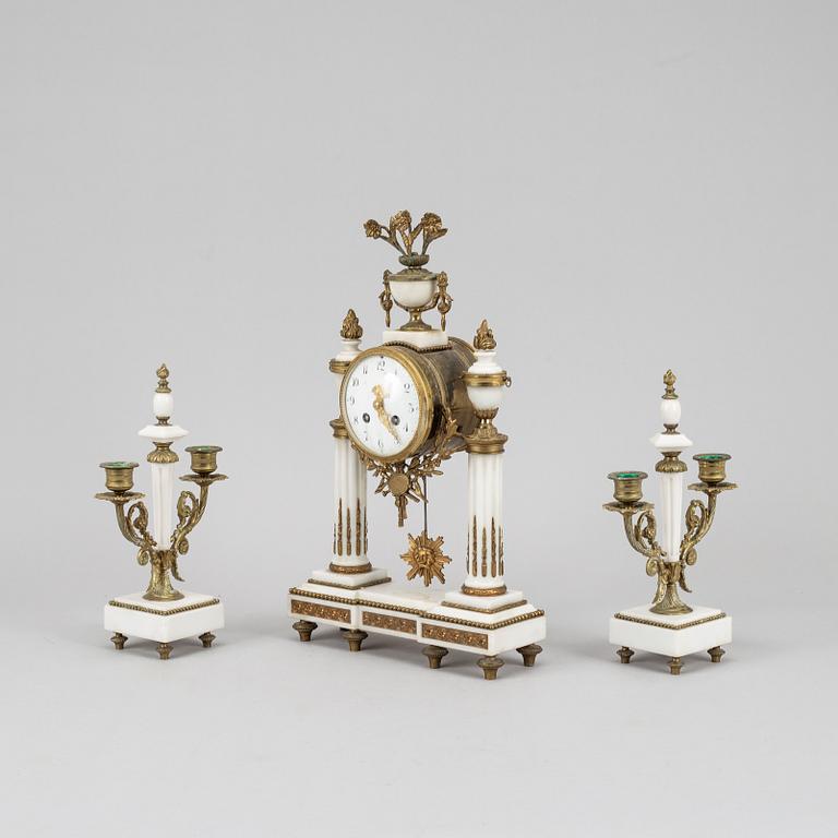 A Louis XVI style pendulum clock and a pair of candelabra, early 20th century.