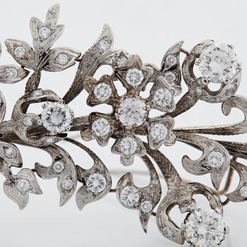 An 18K white gold brooch set with round brilliant-cut diamonds.