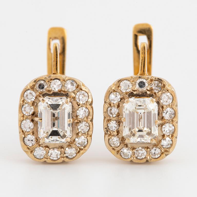 A pair of earrings in 18K gold set with emerald-cut diamonds.