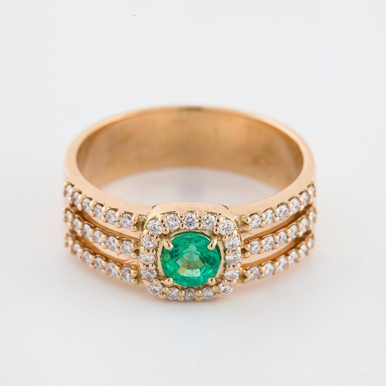 A faceted emerald and brilliant cut diamond ring.