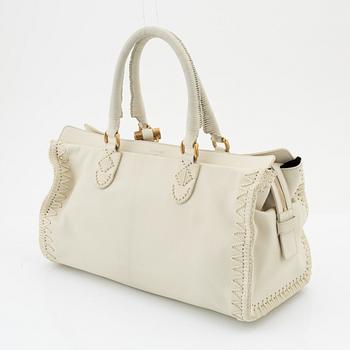 Yves Saint Laurent, a cream coloured goatskin bag with crocheted details.