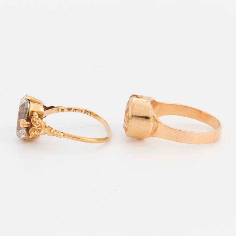Two 18K gold rings set with synthetic, white spinels.