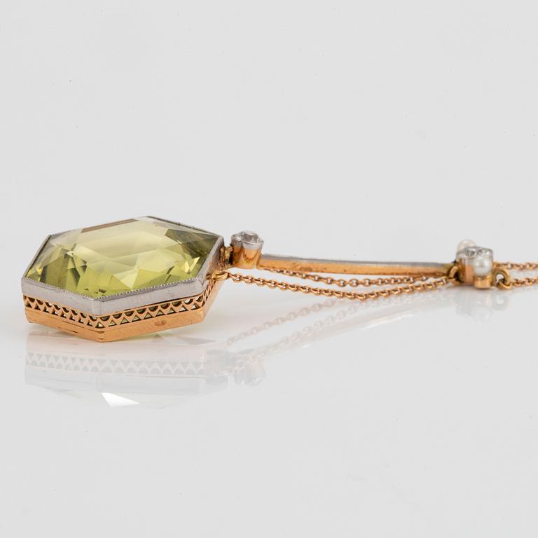 An 18K gold and platinum pendant set with a faceted beryl, old-cut diamonds and pearls.