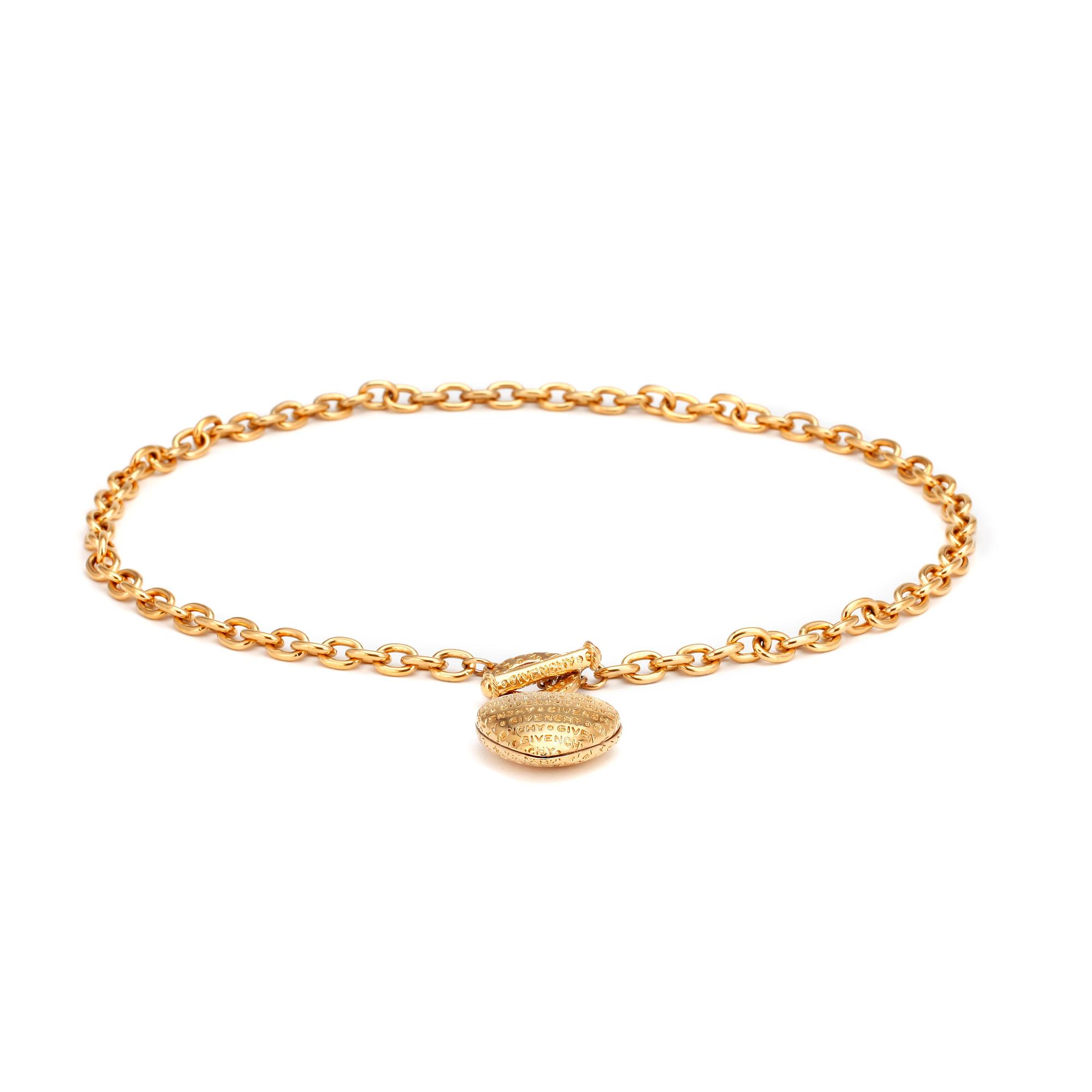 GIVENCHY, a gold colored necklace with heart shaped pendant.