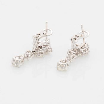 A pair of 18K white gold earrings set with round and oval brilliant-cut diamonds.