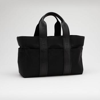 HERMÈS, a black nylon bag with leather details.