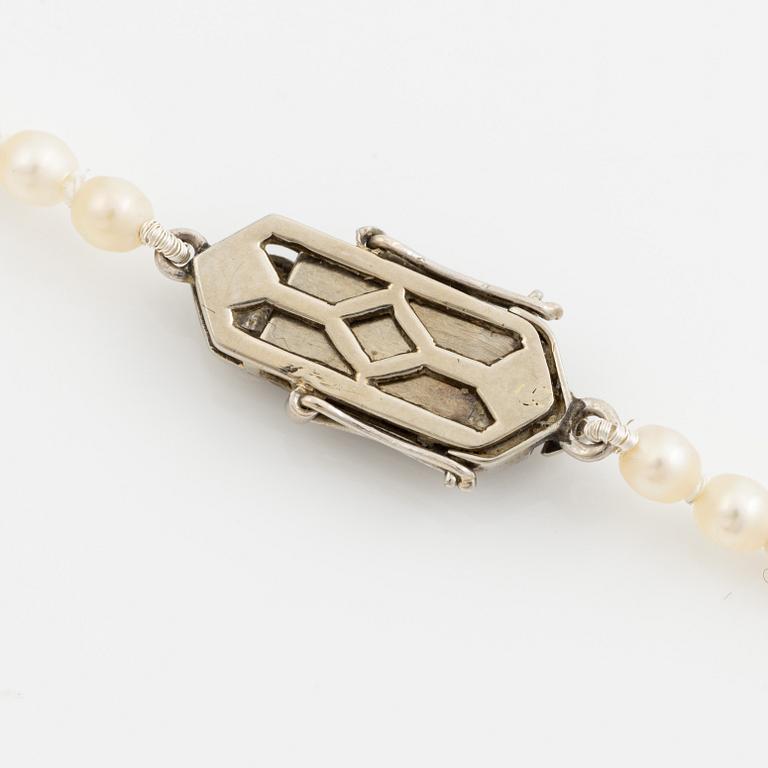 Collier med doserade pärlor, lås vitguld med tre gammalslipade diamanter.