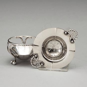 A Georg Jensen tea strainer on stand, Copenhagen 1915-21, 830/1000 silver.