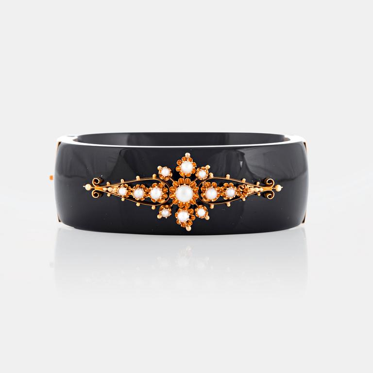 An onyx and 18K gold bracelet set with pearls.