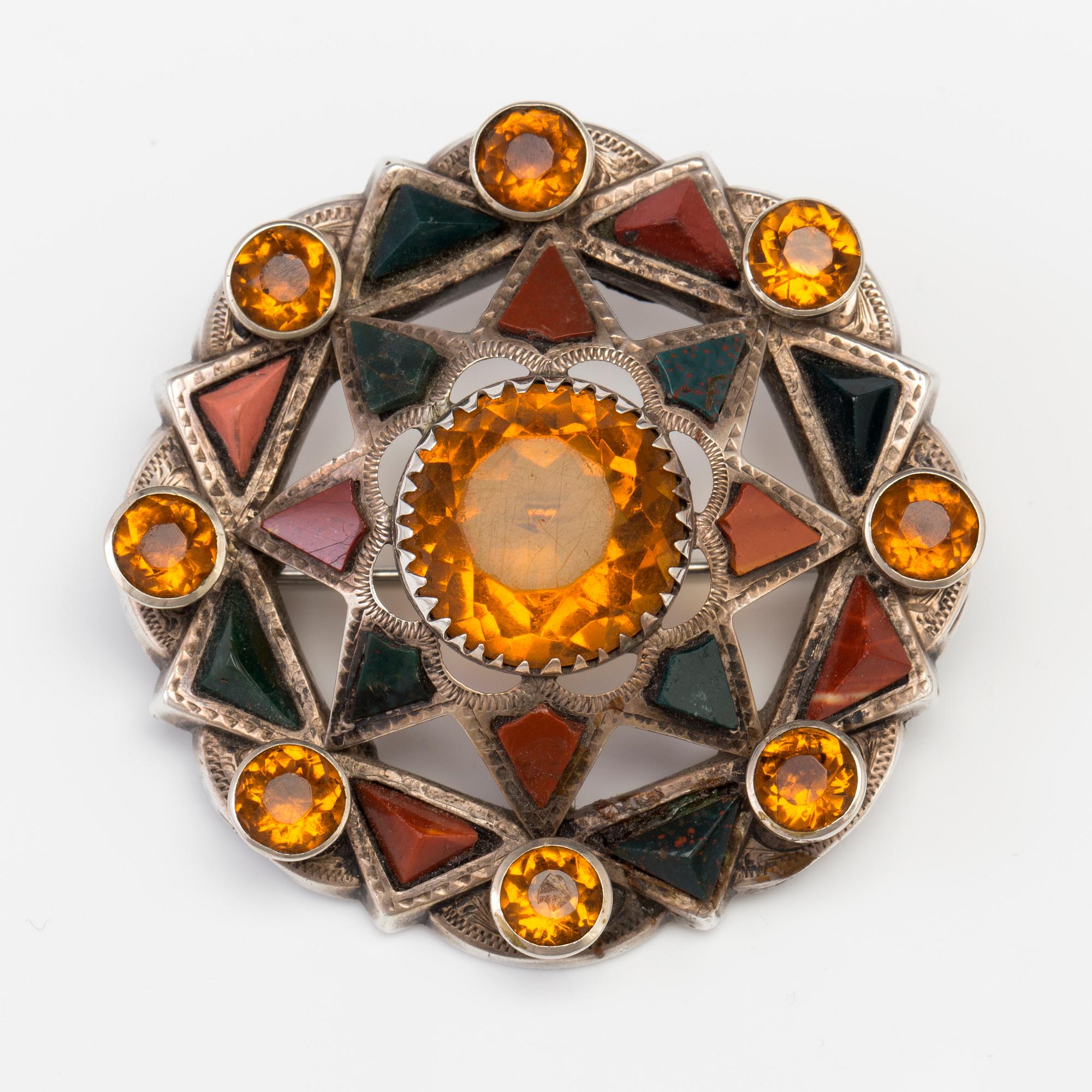 A BROOCH set with amber-coloured paste, heliotrope and jasper.