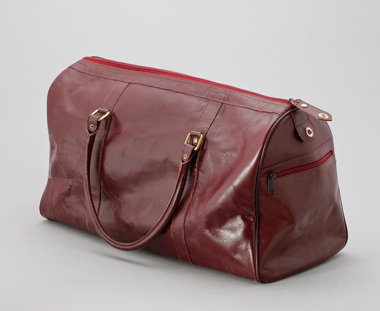 A bordeaux coloured leather weekendbag by Cartier.