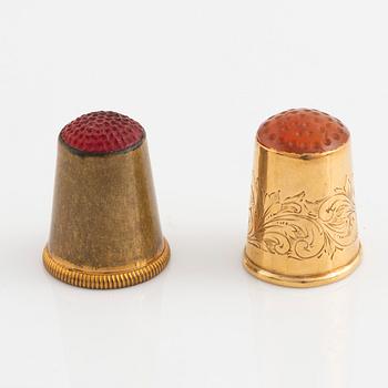 Two thimbles, 18K gold and brass.