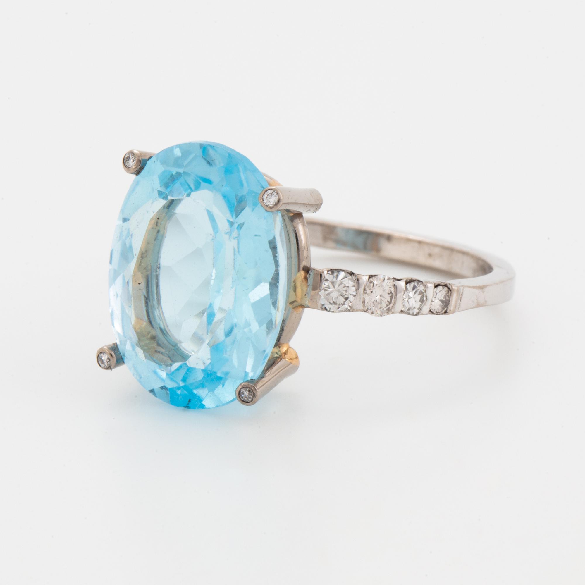Oval faceted blue topaz and brilliant-cut diamond cocktail ring.