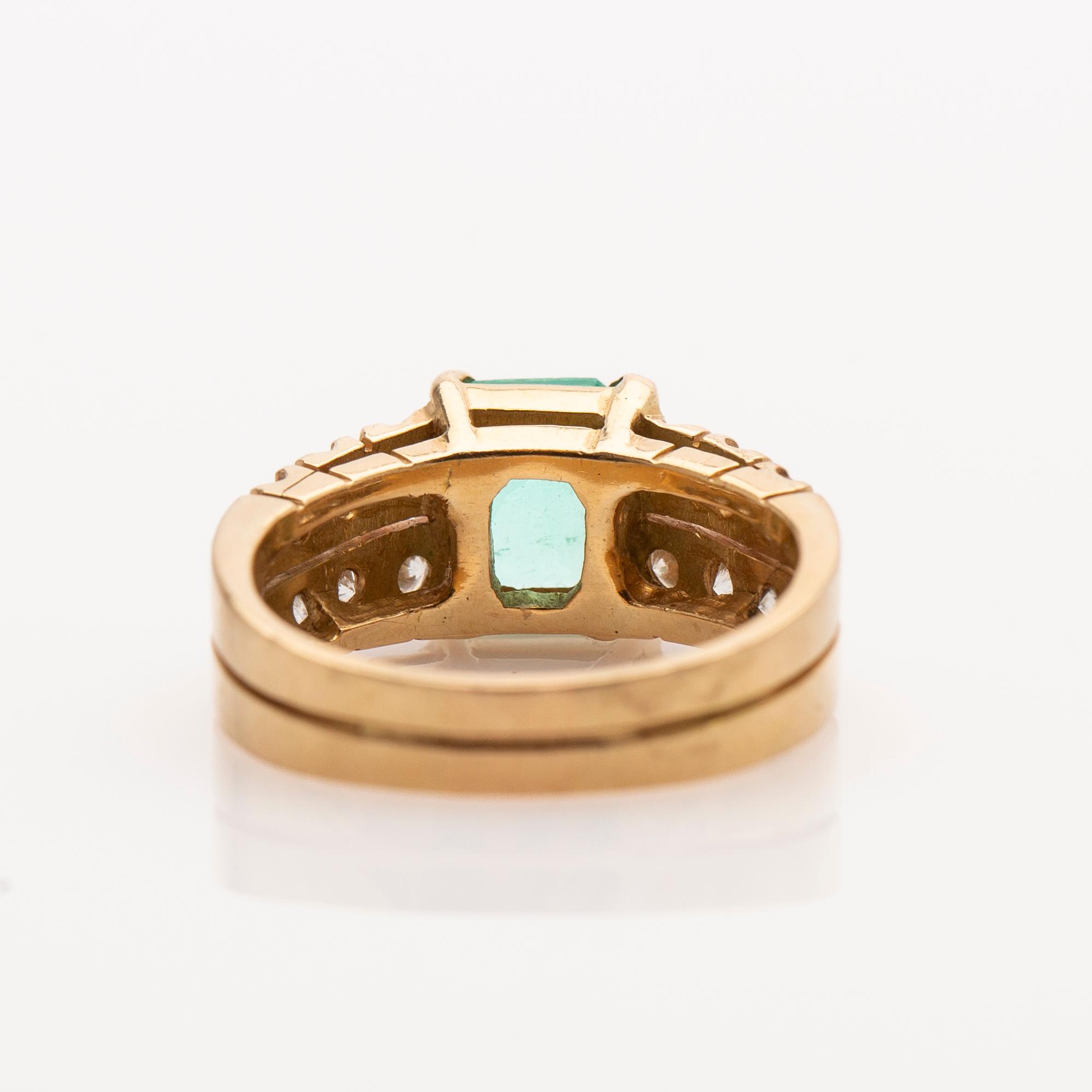 Ring, 18K gold with an emerald set in it and 12 brilliant-cut diamonds.