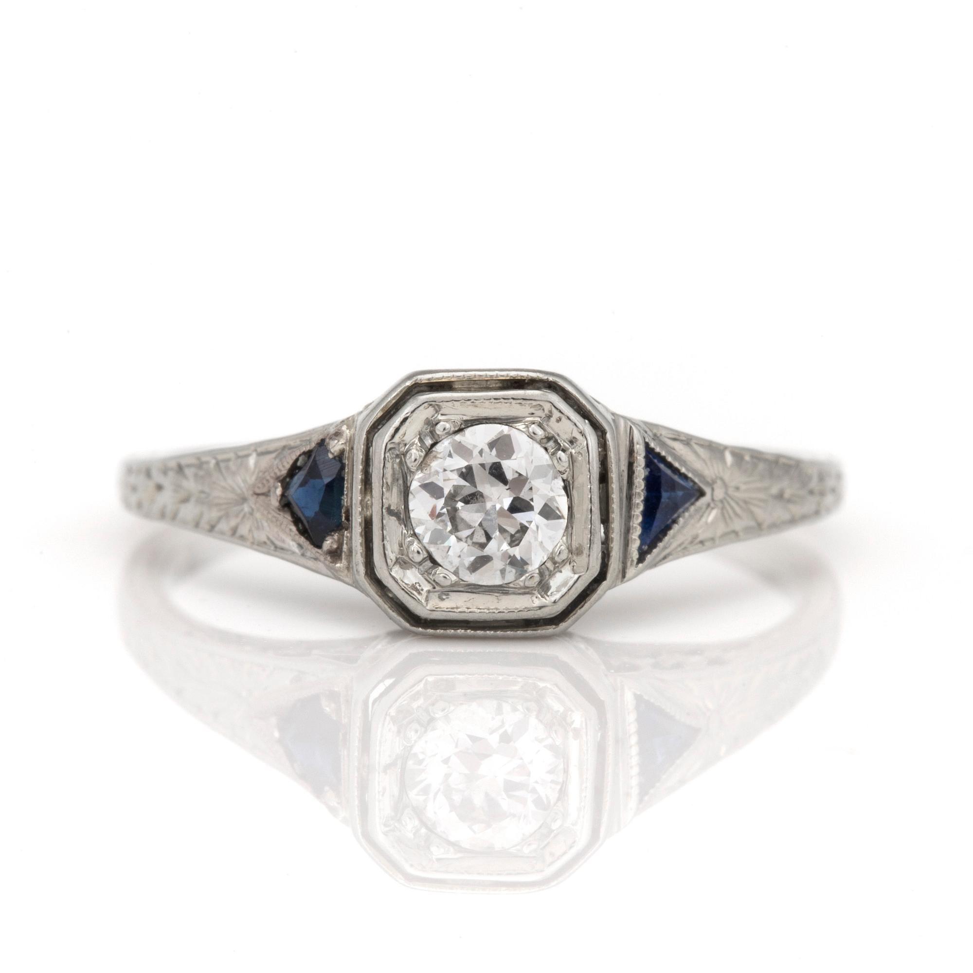 A ring with a round, old-cut diamond and probably faceted sapphires.