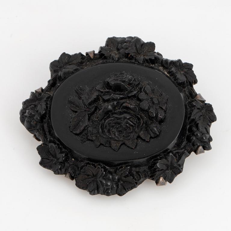 Carved possibly jet/coal and silver brooch.