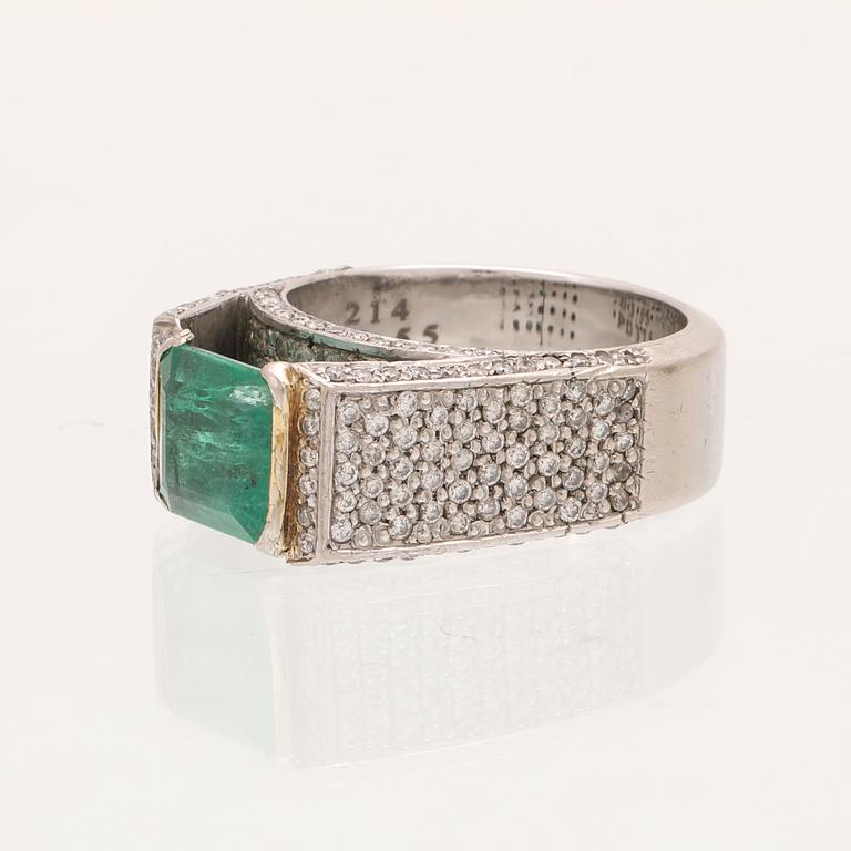 A 9K white gold ring with an emerald and brilliant cut diamonds.