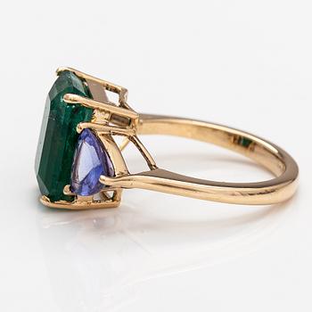 A 14K gold ring with tanzanites and a ca 5.80 ct emerald.