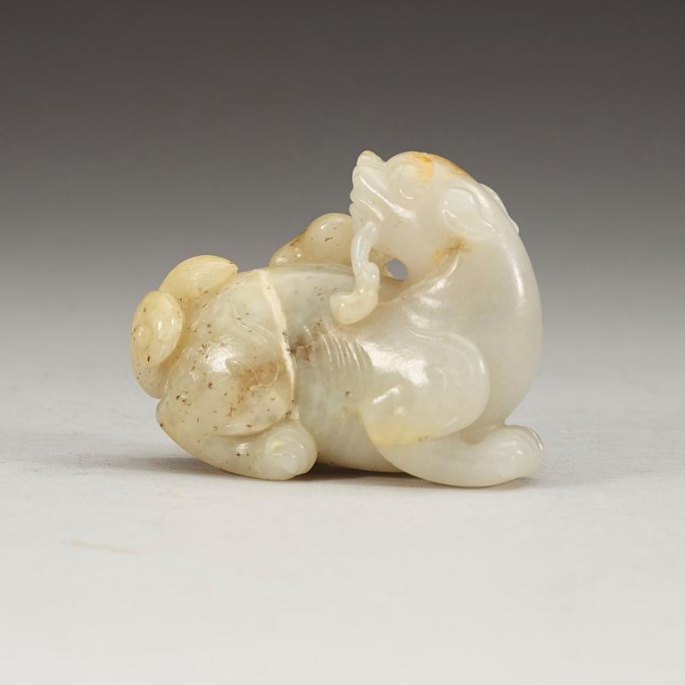 A carved nephrite figure of a reclining dragon carrying lingzhi fungus in his mouth, Qing dynasty (1644-1912).