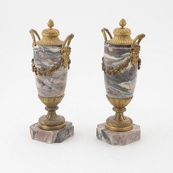 A pair of Louis XVI style urns with covers.