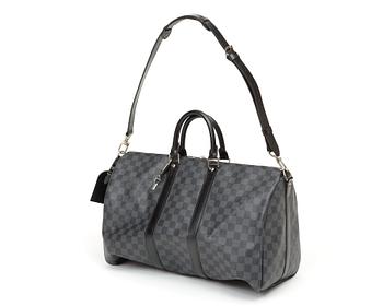 A black damier ebene canvas weekend bag by Louis Vuitton.